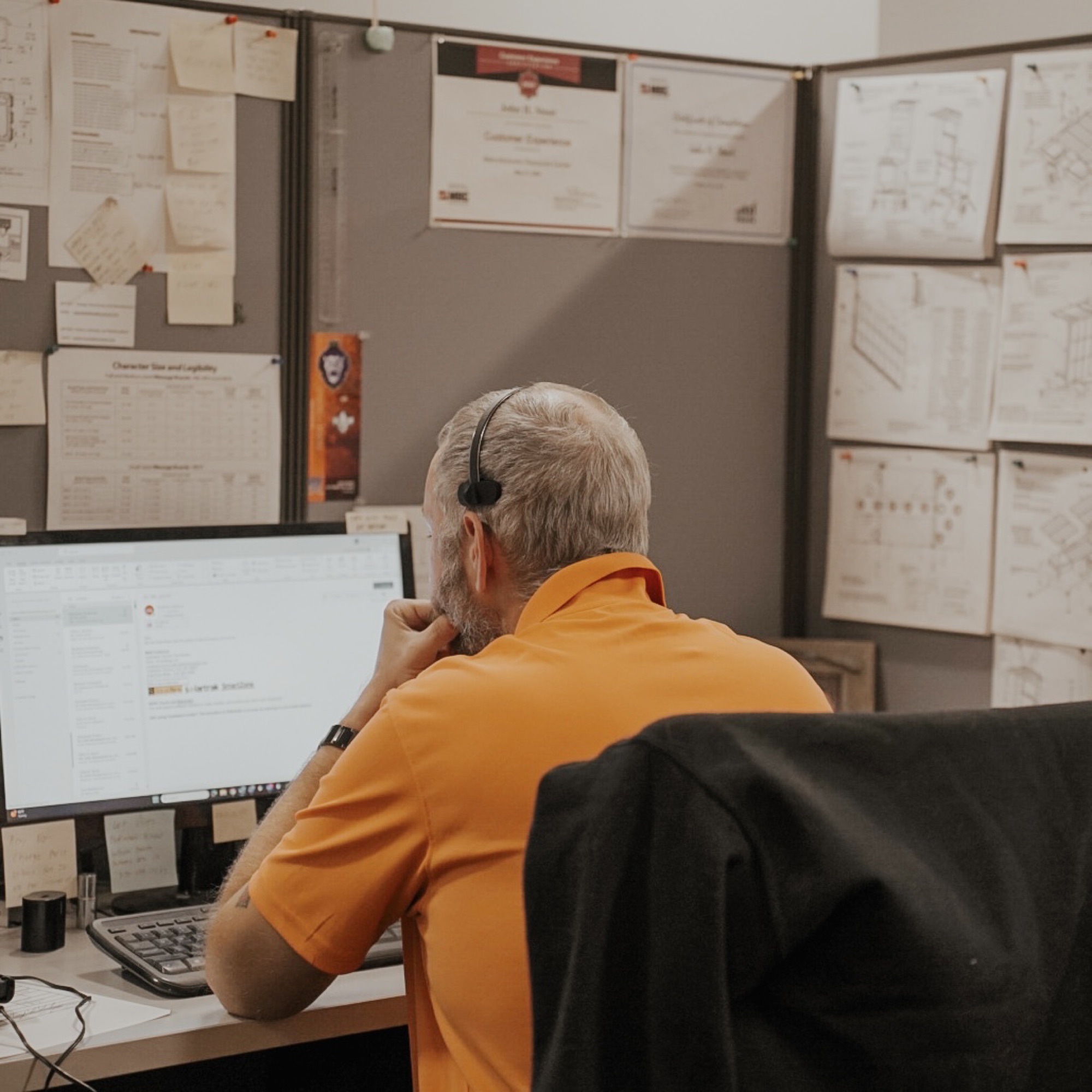 A SolarTech support team member at their desk, wearing a headset